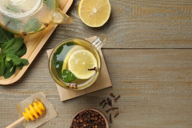 Glass cup of immunity boosting drink and ingredients on wooden table, flat lay. Space for text