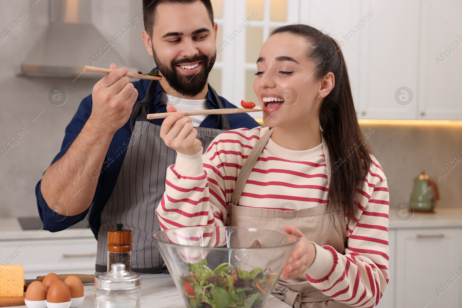 Photo of Happy lovely couple cooking together in kitchen