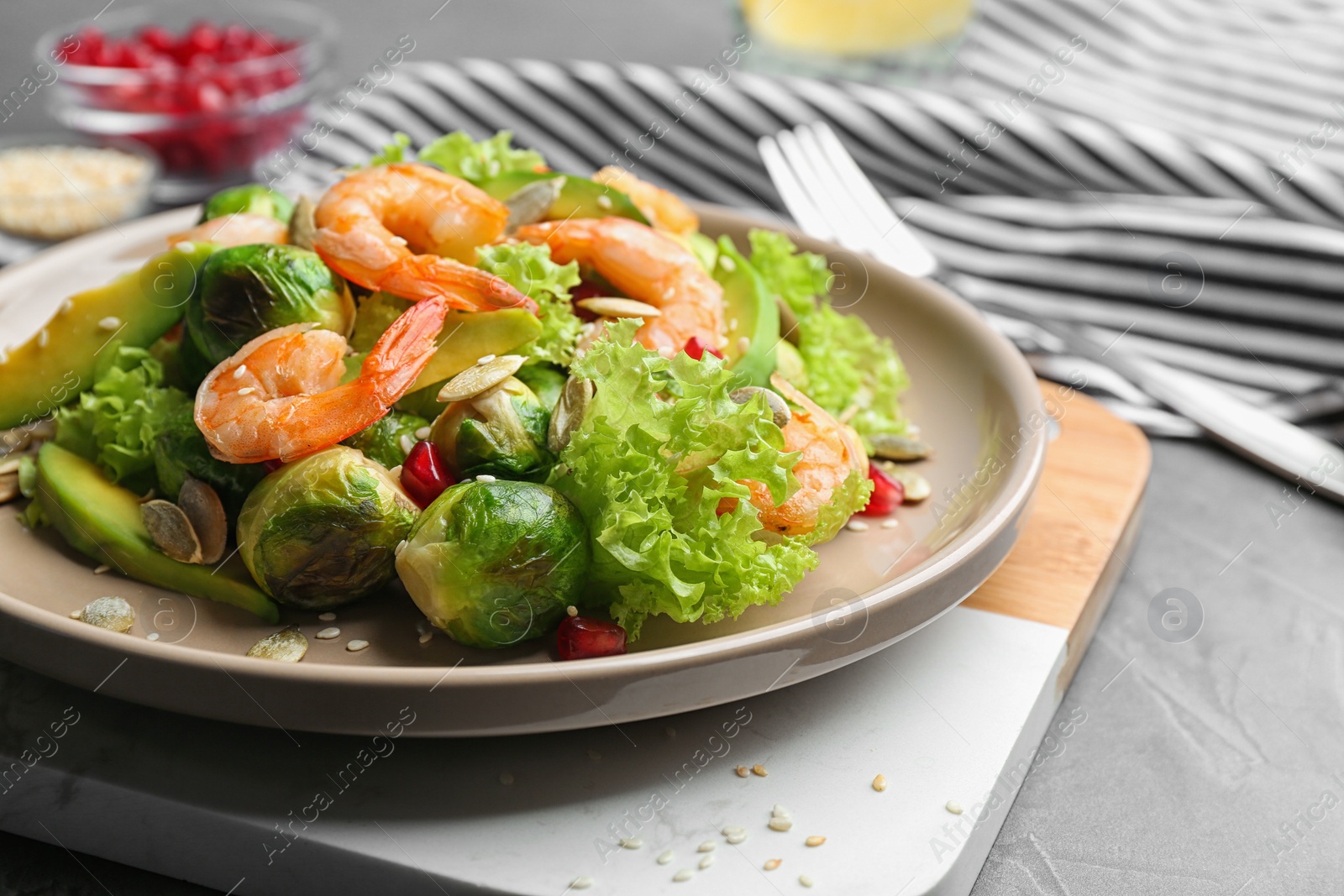 Photo of Tasty salad with Brussels sprouts served on grey table