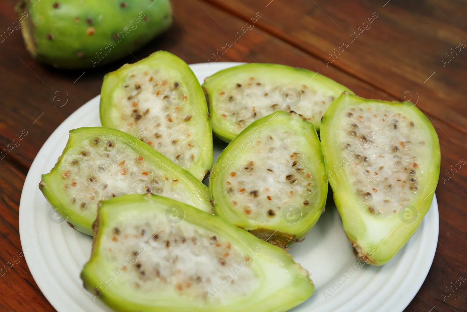 Photo of Tasty prickly pear fruits on wooden table, closeup
