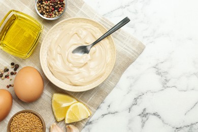 Photo of Bowl with fresh mayonnaise and ingredients on white marble table, top view. Space for text