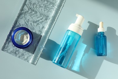 Set of cosmetic products on light blue background, flat lay