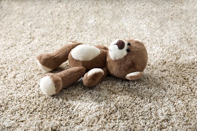 Photo of Cute lonely teddy bear on floor in room