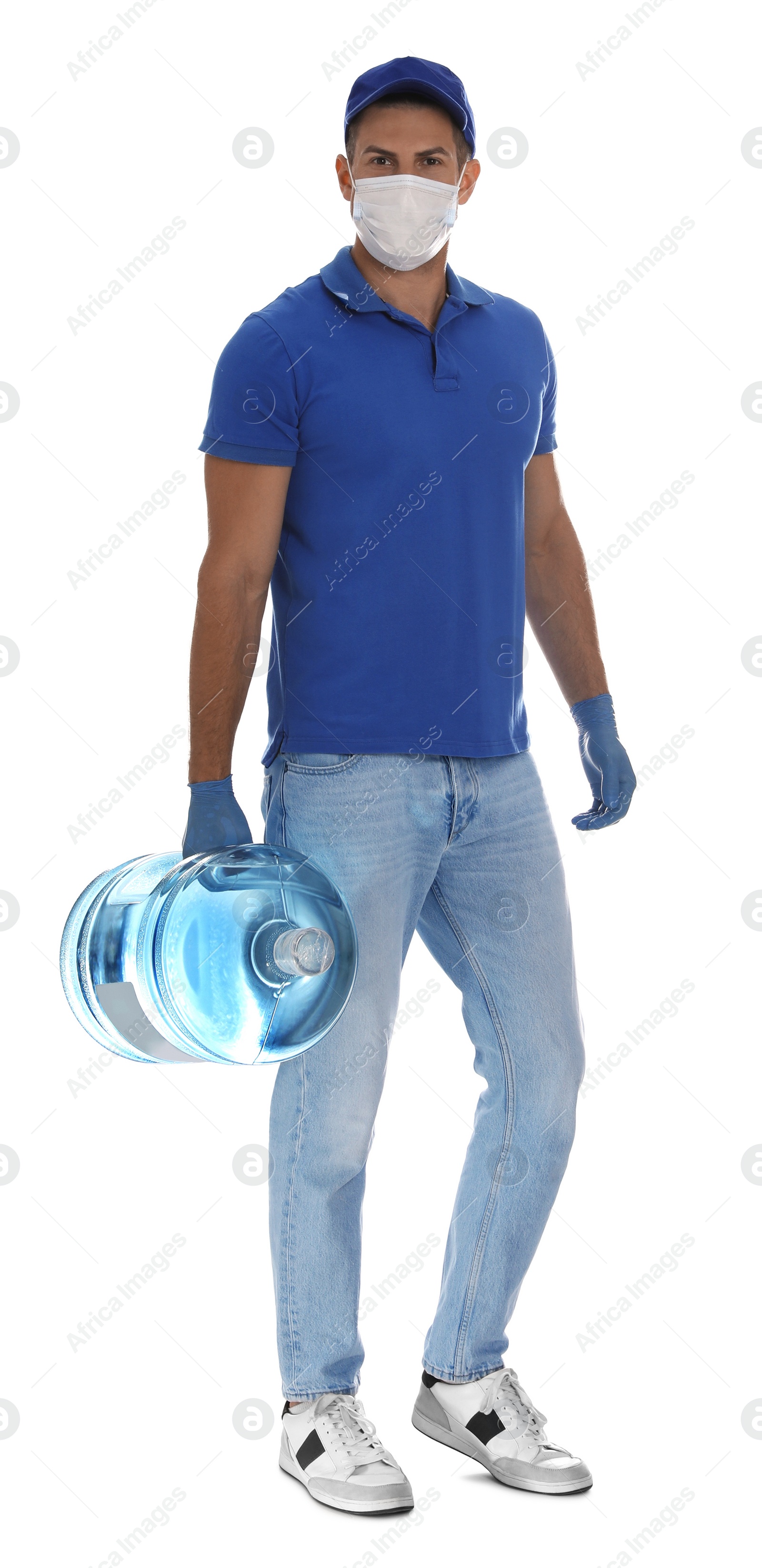 Photo of Courier in medical mask holding bottle for water cooler on white background. Delivery during coronavirus quarantine