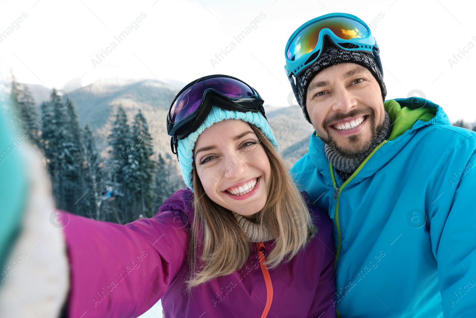 Photo of Happy couple taking selfie during winter vacation in mountains