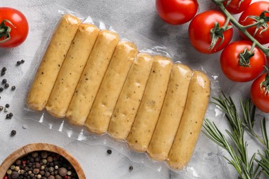 Photo of Vegan sausages and products on white marble table, flat lay