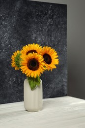 Photo of Vase with beautiful sunflowers and double-sided backdrop in photo studio