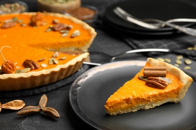 Photo of Delicious homemade pumpkin pie on black table