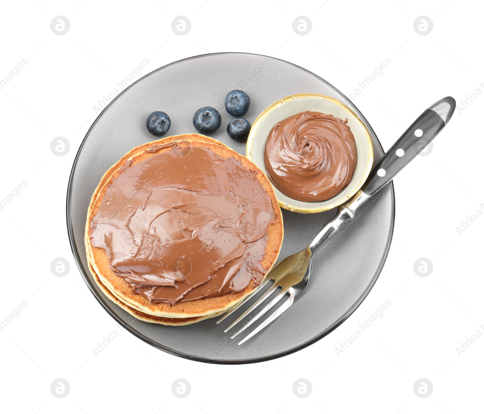Photo of Delicious pancakes with chocolate paste, blueberries and fork isolated on white, top view
