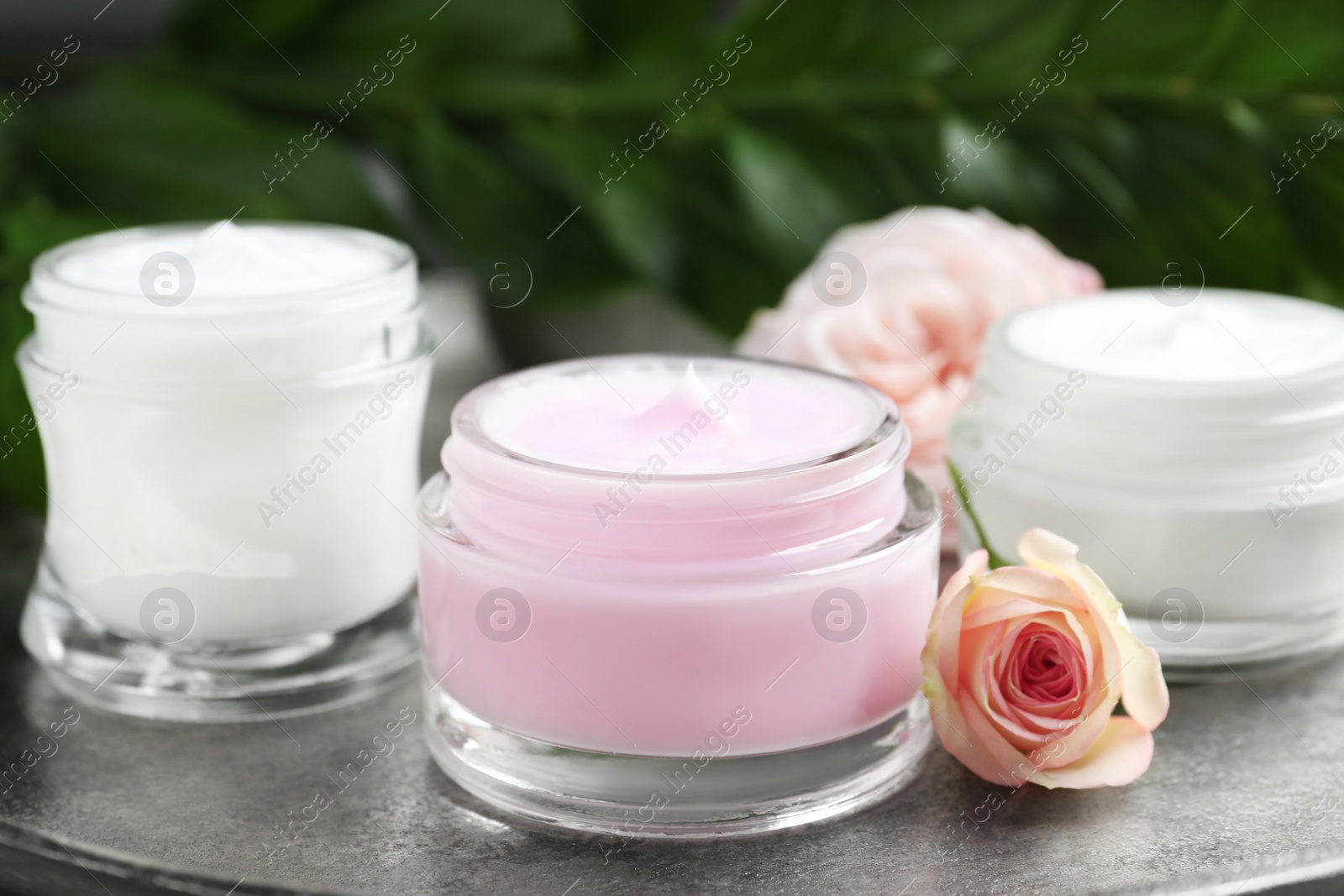 Photo of Jar of organic cream and flower on grey stone table