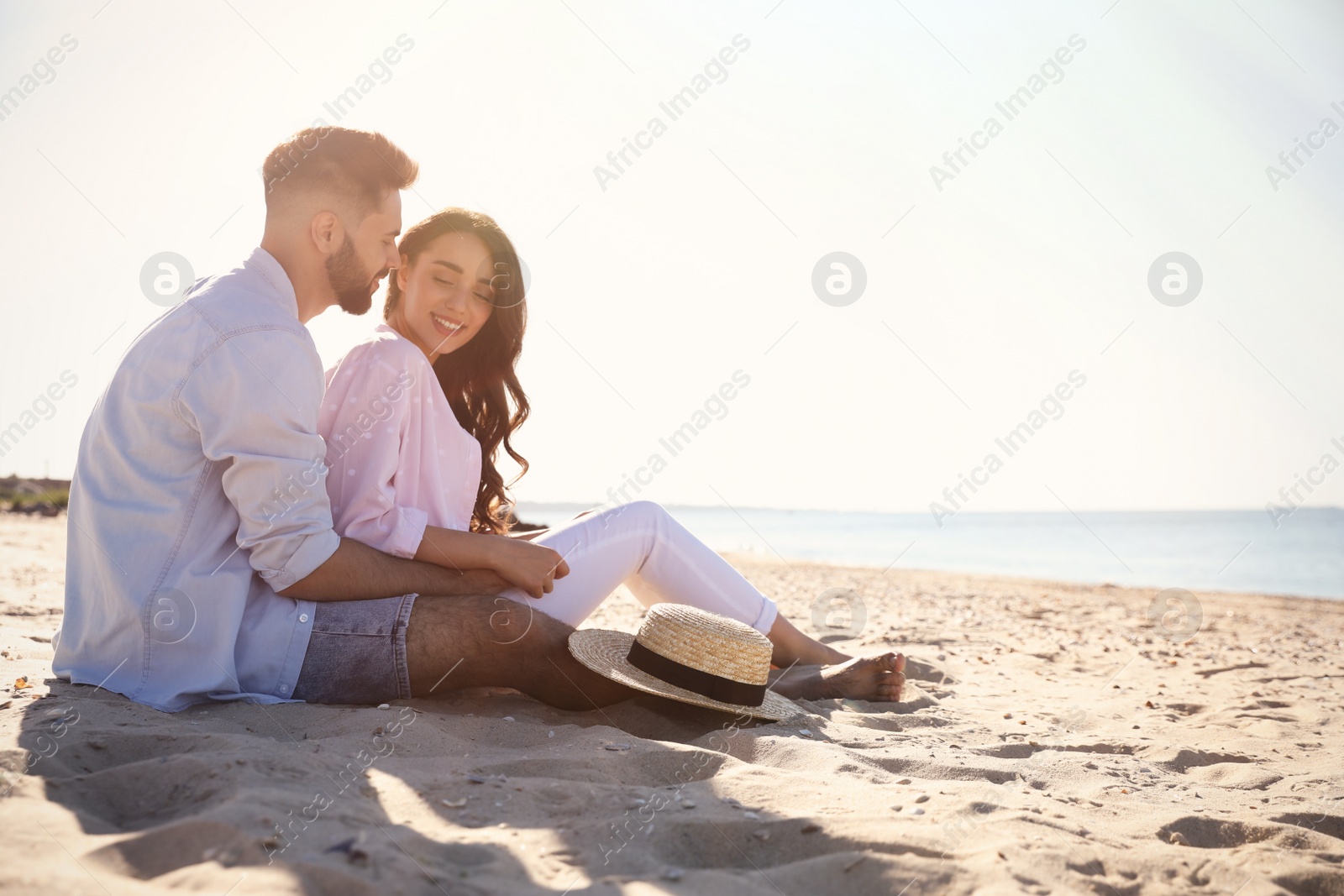 Photo of Happy young couple on beach near sea. Honeymoon trip