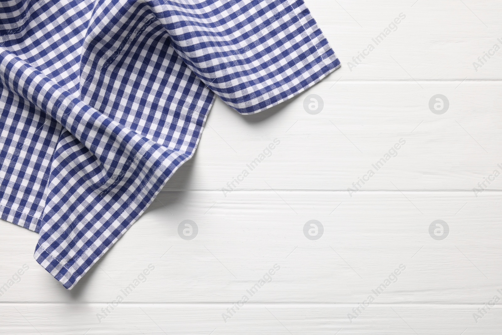 Photo of Blue checkered tablecloth on wooden table, top view. Space for text