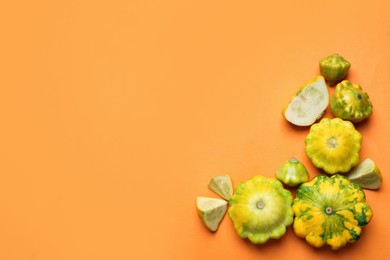 Photo of Fresh ripe pattypan squashes on orange background, flat lay. Space for text