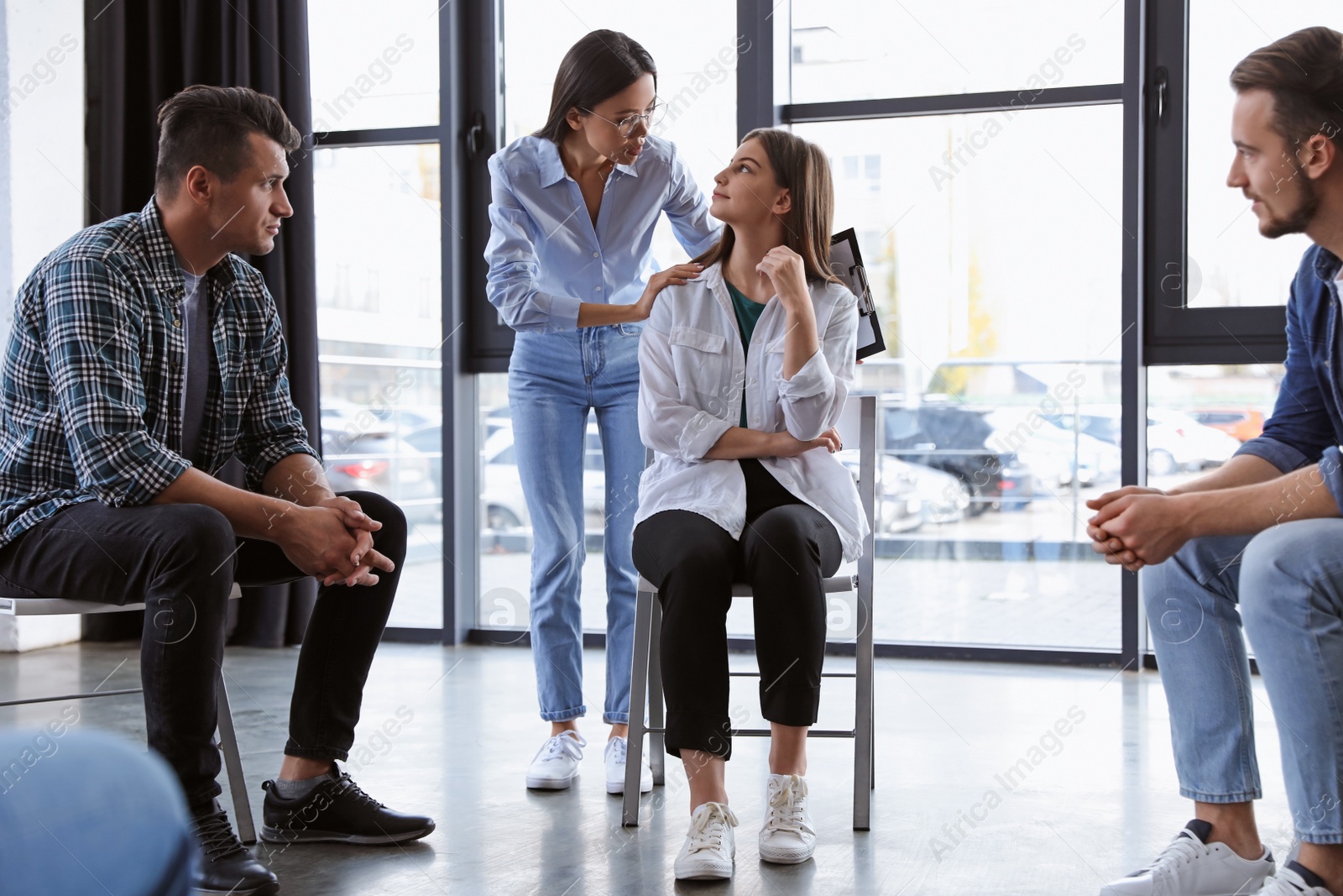 Photo of Psychotherapist working with patients in group therapy session indoors