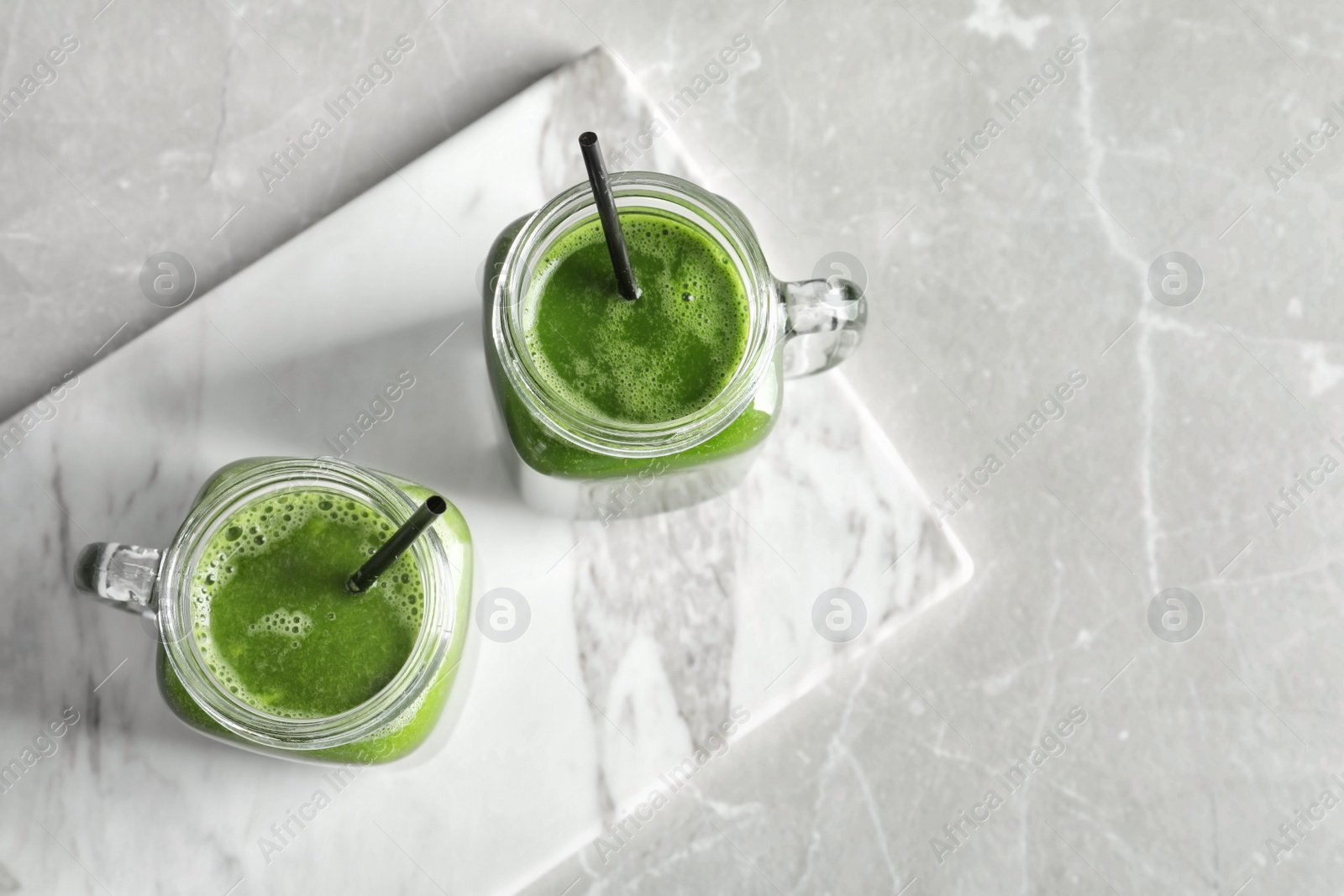 Photo of Mason jars with delicious detox juice on table, top view