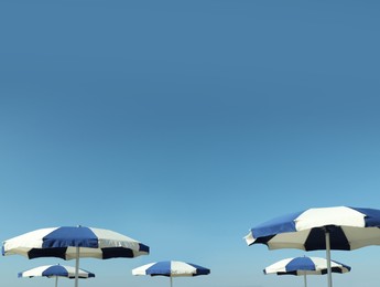 Photo of Beach umbrellas against blue sky on sunny day