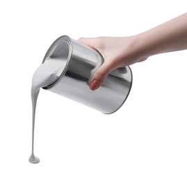 Photo of Woman pouring paint from can on white background, closeup