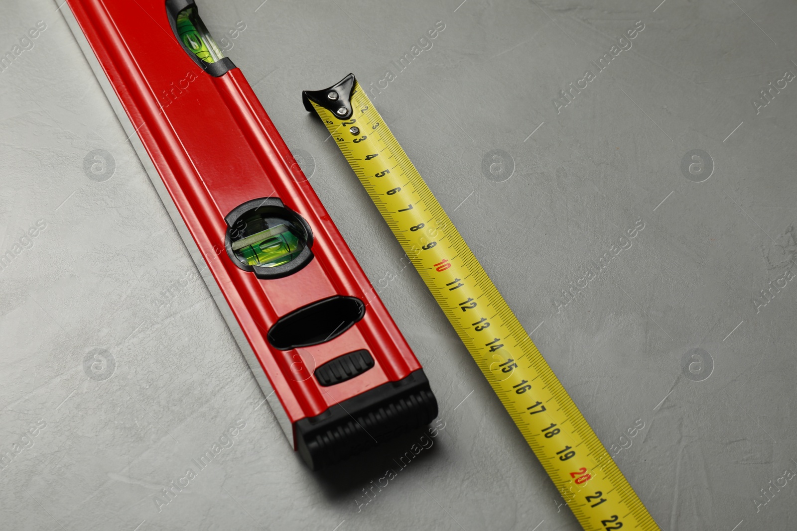 Photo of Building level and tape measure on grey table