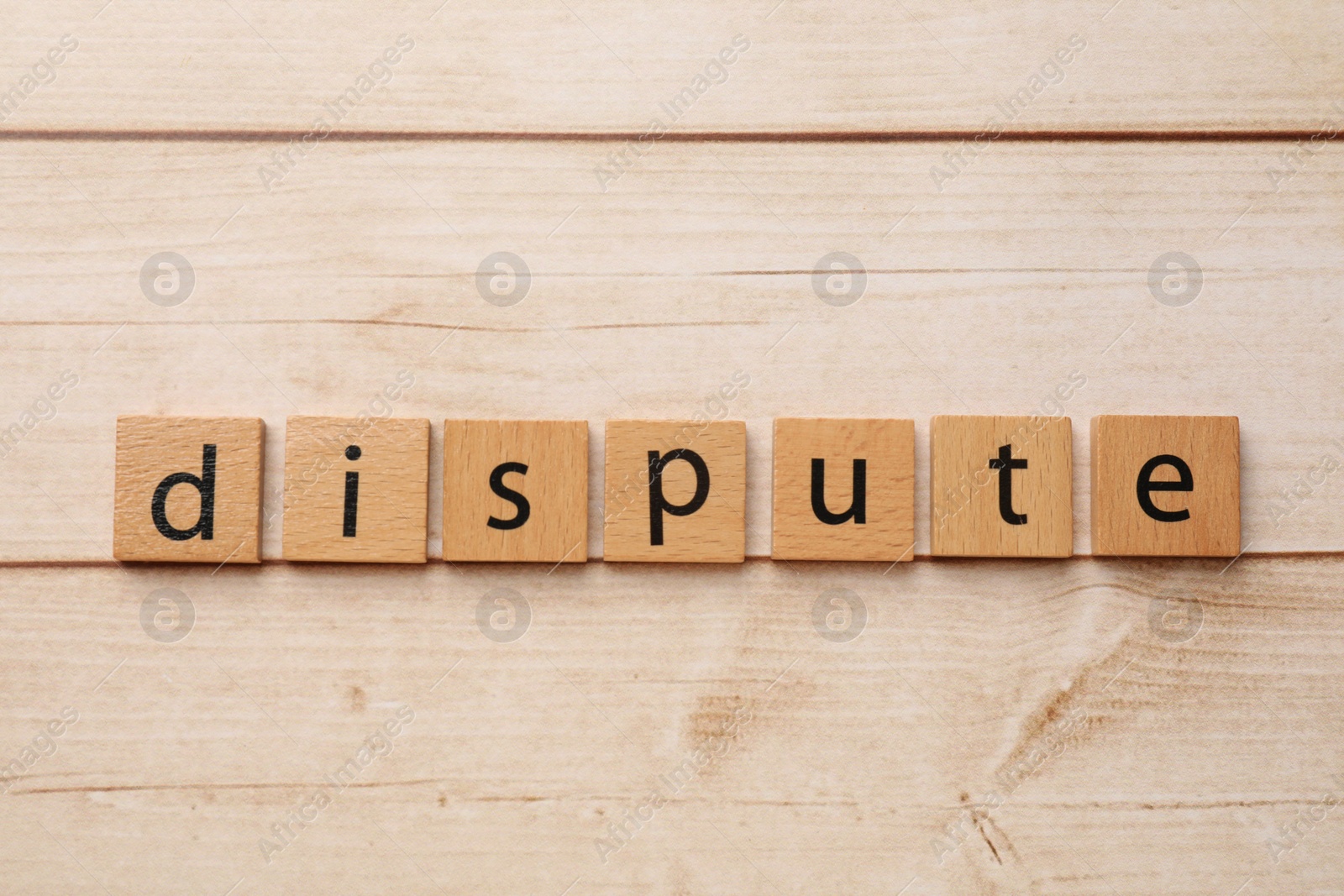 Photo of Squares with word Dispute on light wooden table, top view