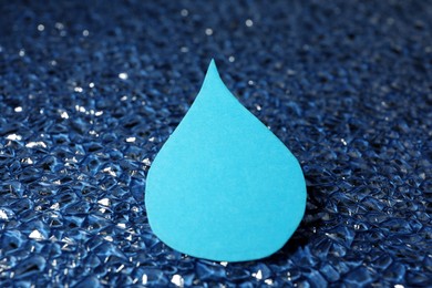 Photo of Water drop on blue crystal surface, closeup