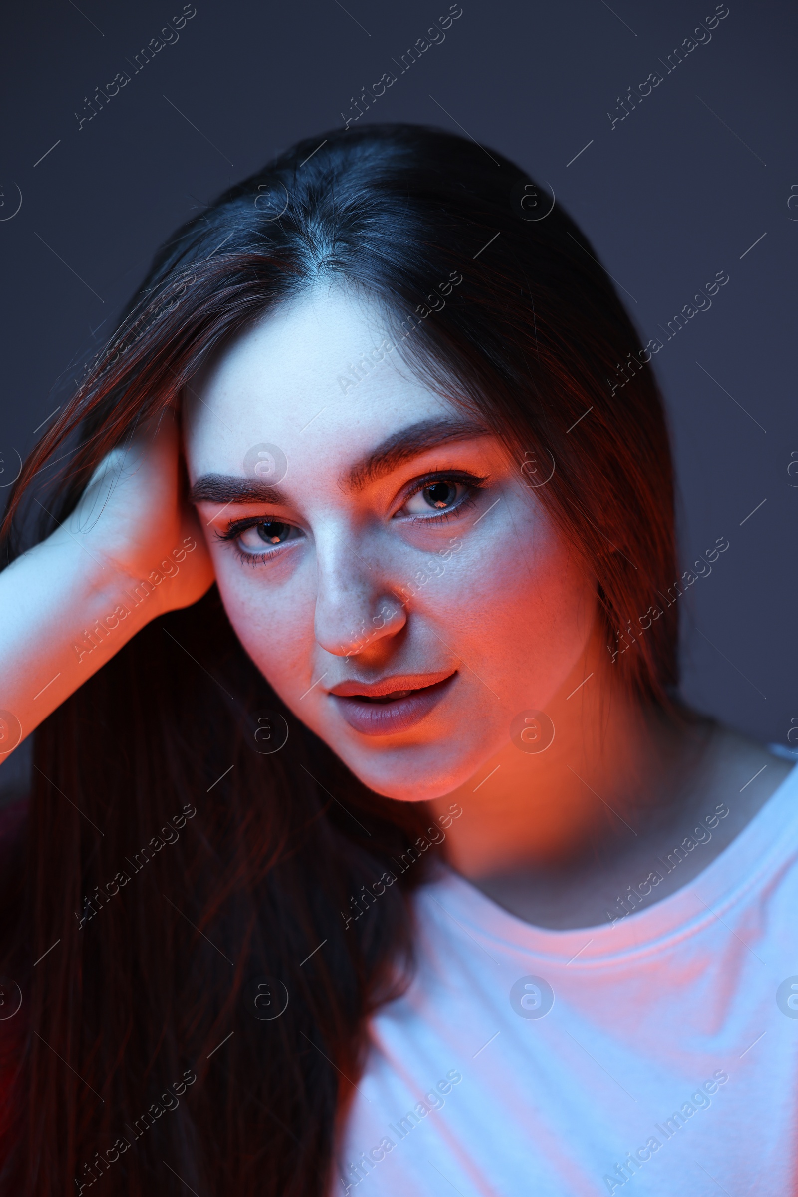 Photo of Portrait of beautiful woman on dark blue background in neon lights, closeup