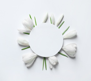 Photo of Beautiful spring crocus flowers and card on white background, top view. Space for text