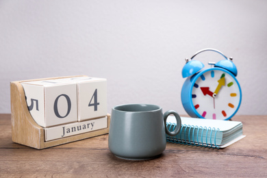 Composition with calendar and cup of hot drink on wooden table