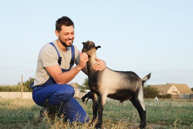 Man feeding goat at farm. Animal husbandry
