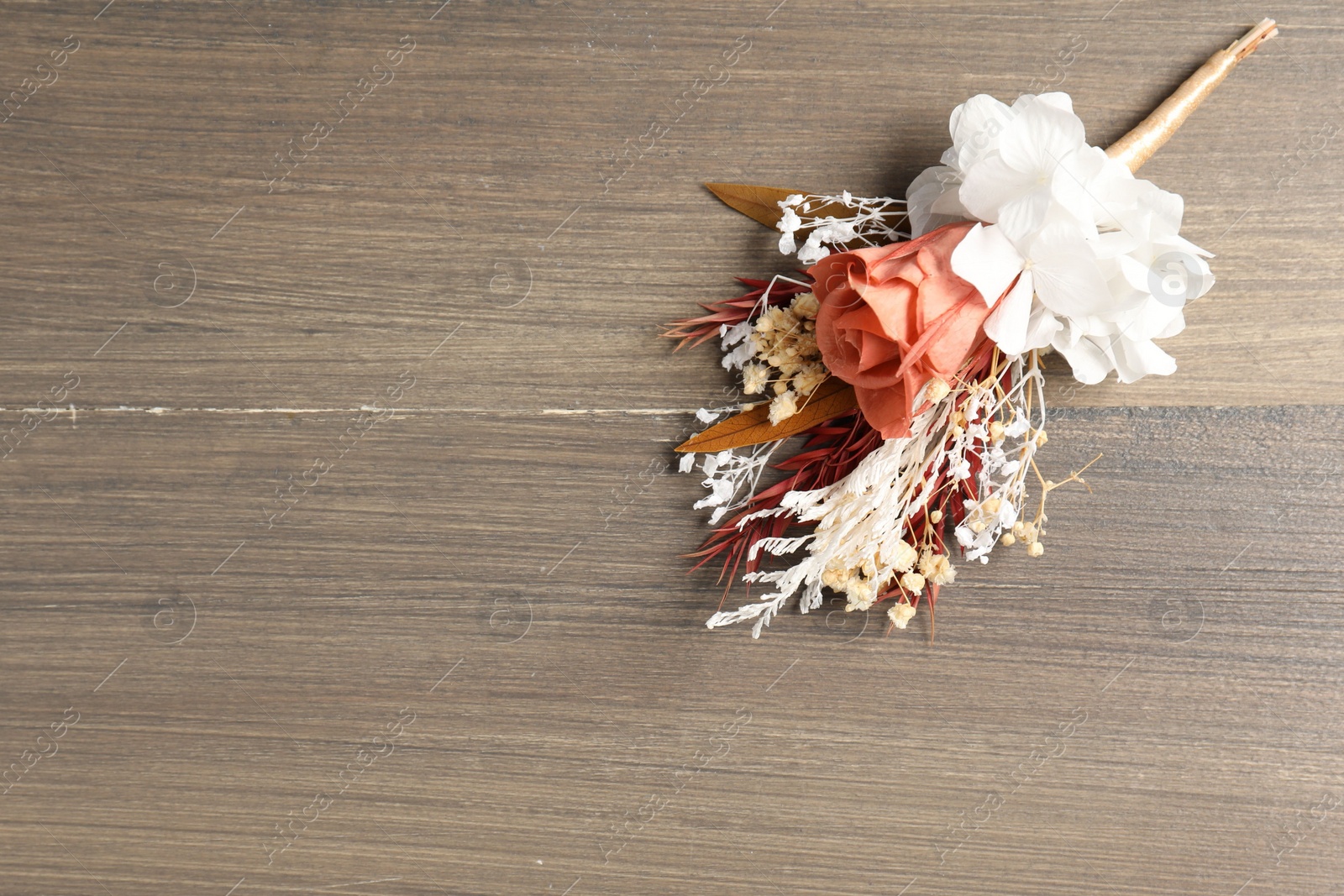 Photo of Beautiful boutonniere on wooden background, top view. Space for text