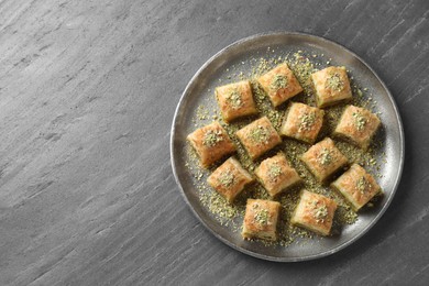Photo of Delicious fresh baklava with chopped nuts on grey table, top view and space for text. Eastern sweets