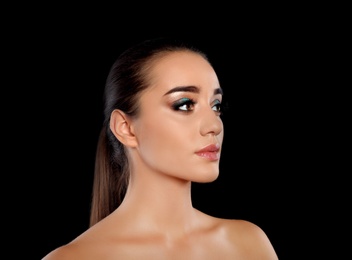 Photo of Portrait of young woman with eyelash extensions and beautiful makeup on black background