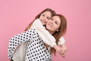 Photo of Portrait of happy mother and her cute daughter on pink background