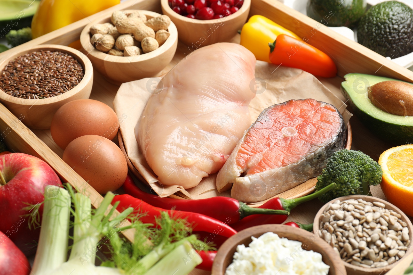 Photo of Raw chicken, salmon, seeds and other healthy food, closeup