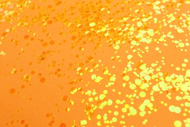 Photo of Shiny bright yellow glitter on pale coral background
