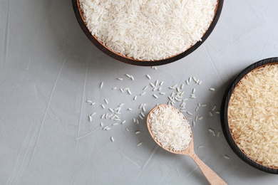 Flat lay composition with long grain and parboiled rice on grey background. Space for text
