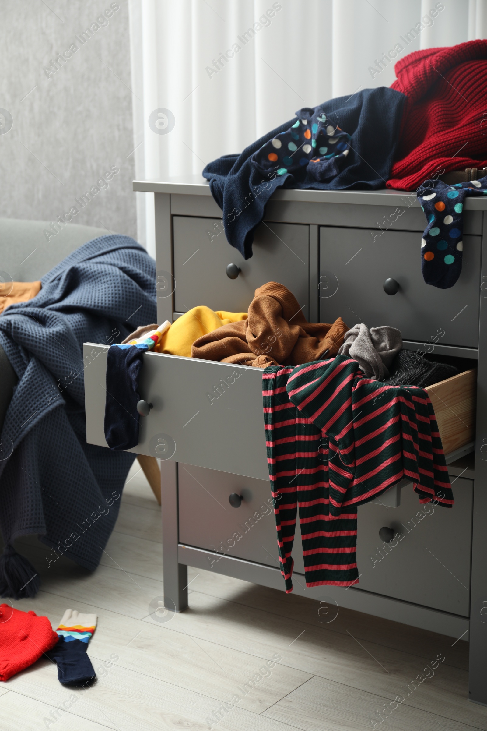 Photo of Cluttered room. Clothes in mess all around place