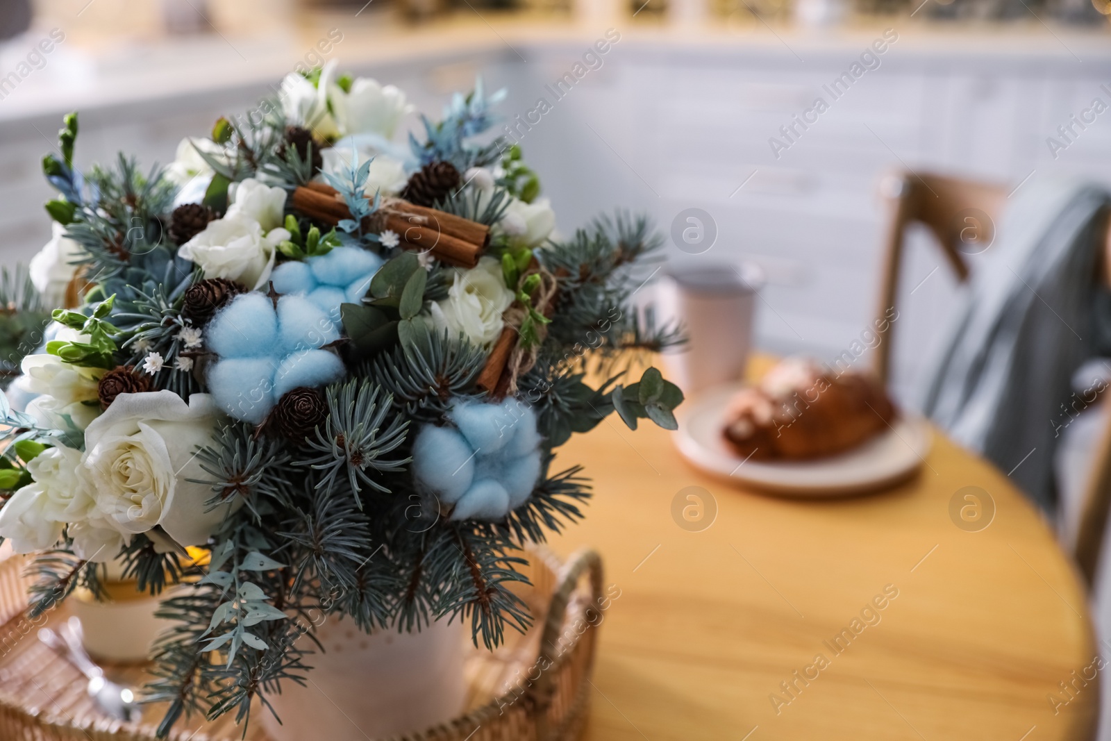Photo of Beautiful winter bouquet on wooden table in kitchen, closeup