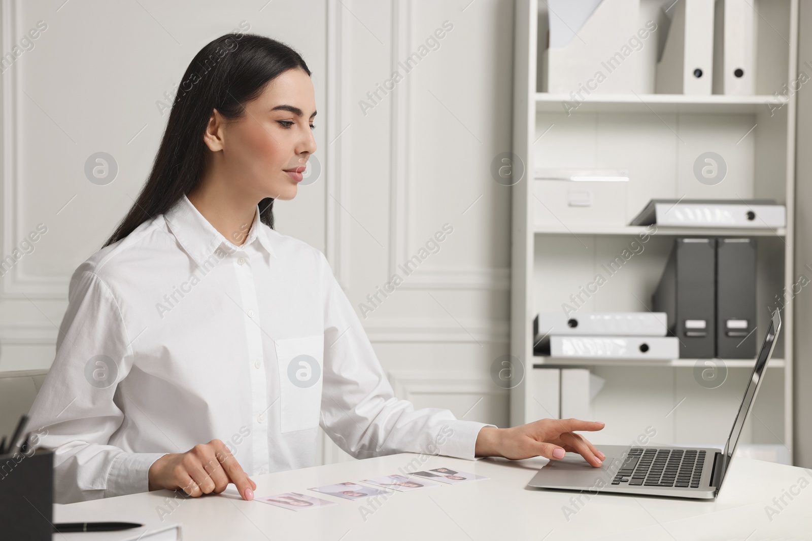 Photo of Human resources manager choosing employee among different applicants in office