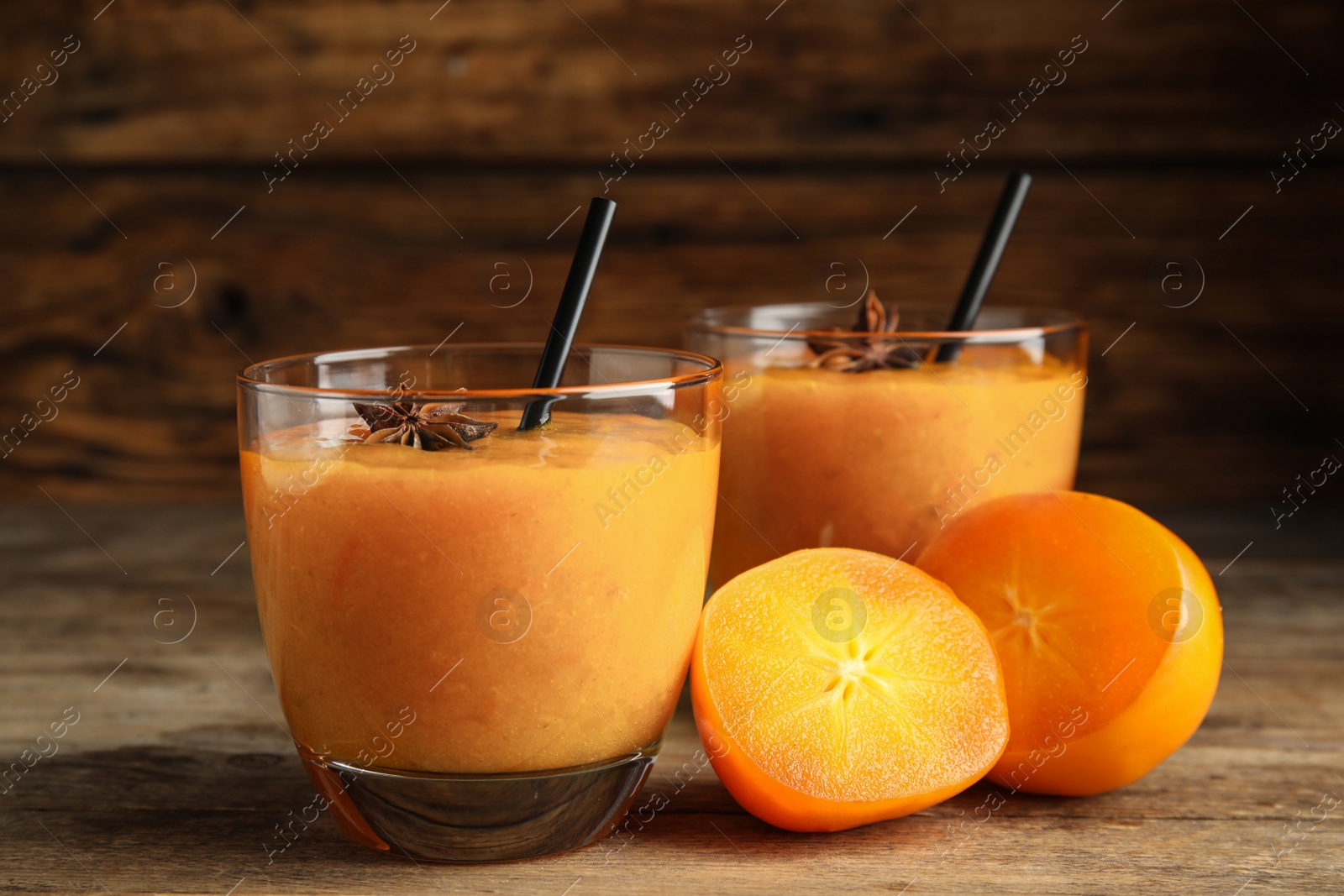 Photo of Tasty persimmon smoothie with anise and fresh fruits on wooden table