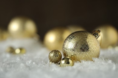 Beautiful Christmas balls on snow against blurred background. Space for text