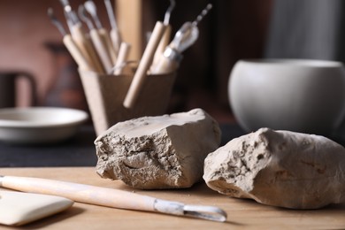 Clay and set of modeling tools on table in workshop, closeup