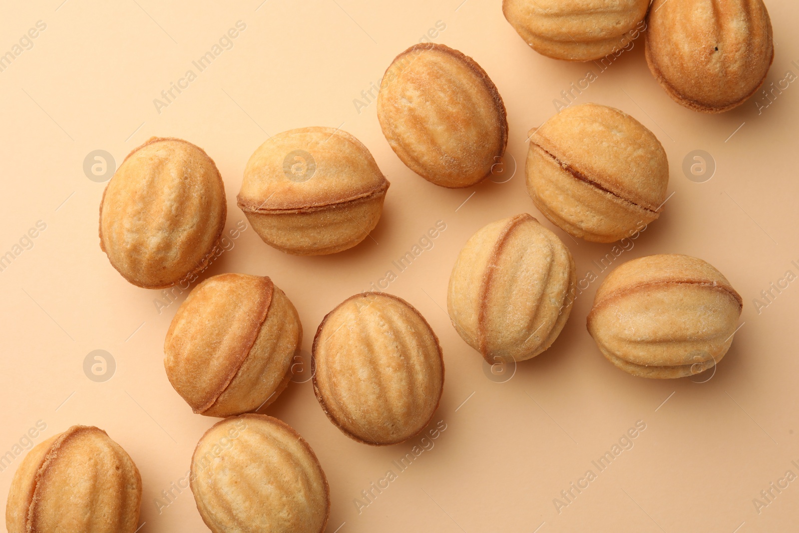 Homemade walnut shaped cookies with condensed milk on beige background, flat lay Photo of Homemade walnut shaped cookies with condensed milk on beige background, flat lay
