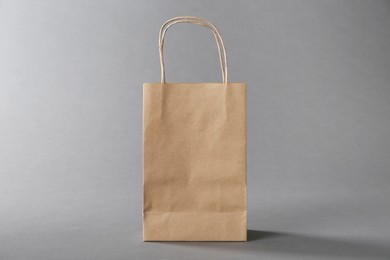 Photo of One kraft paper bag on grey background. Mockup for design