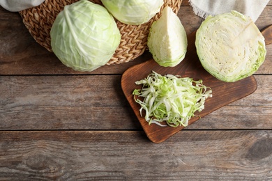 Photo of Fresh cabbage on wooden table, flat lay. Space for text