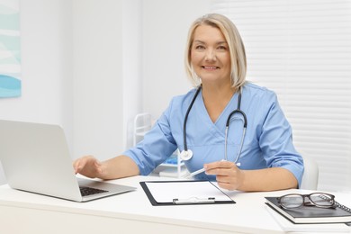 Doctor working at white table in clinic