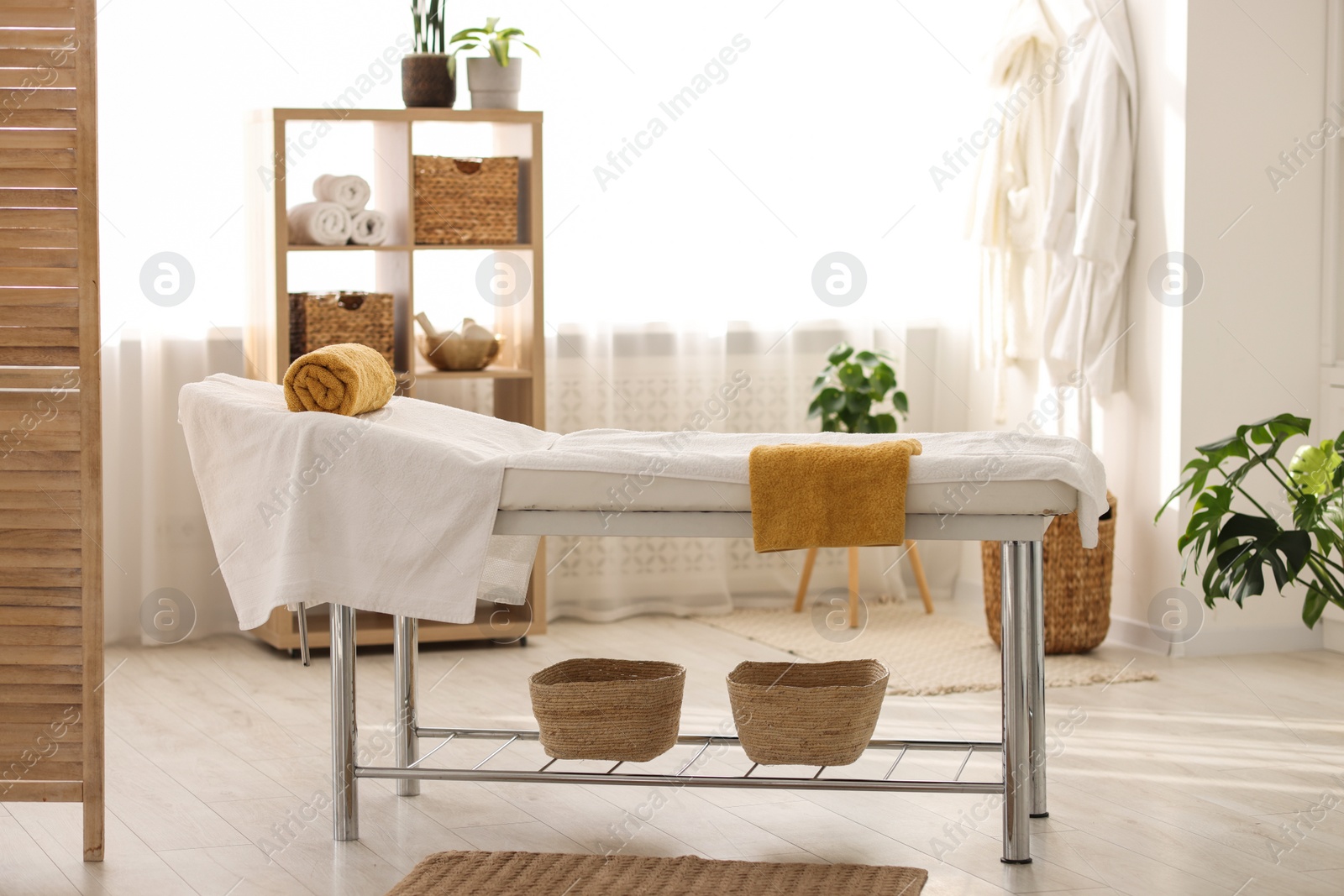 Photo of Comfortable massage table with clean towels in spa center