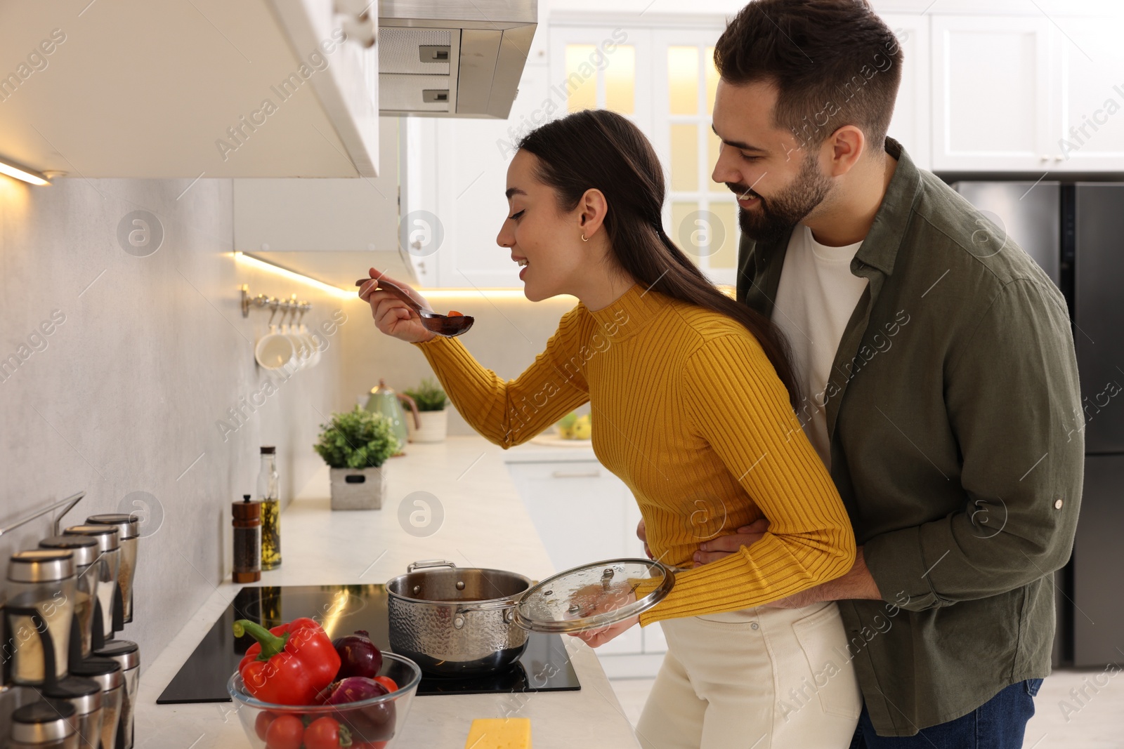 Photo of Lovely young couple cooking together in kitchen