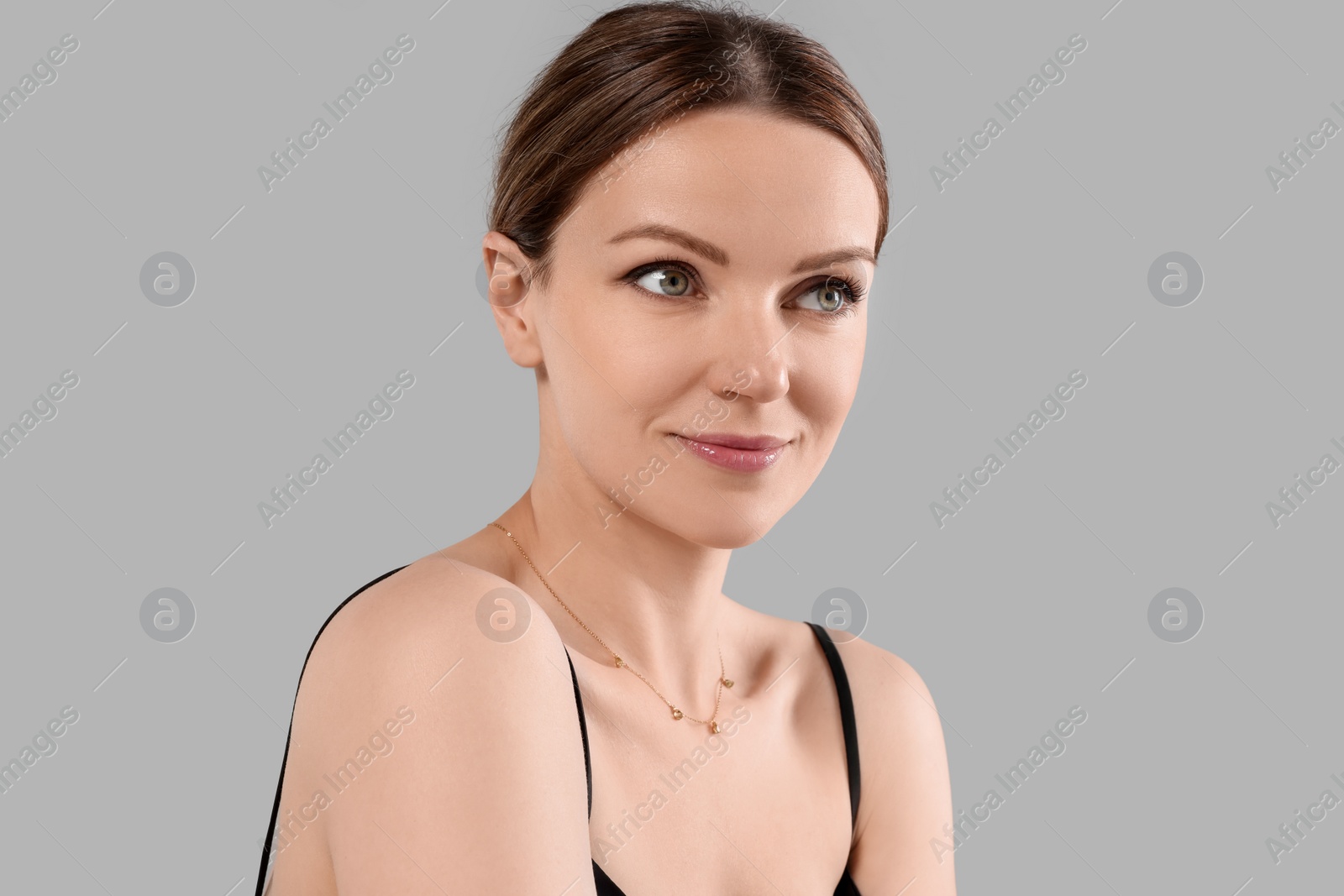 Photo of Beautiful woman with elegant necklace on light grey background