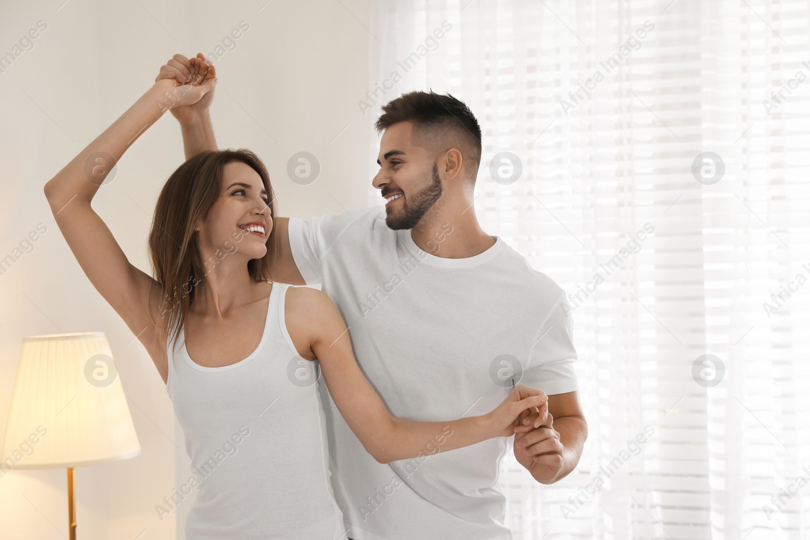 Photo of Lovely young couple dancing together at home