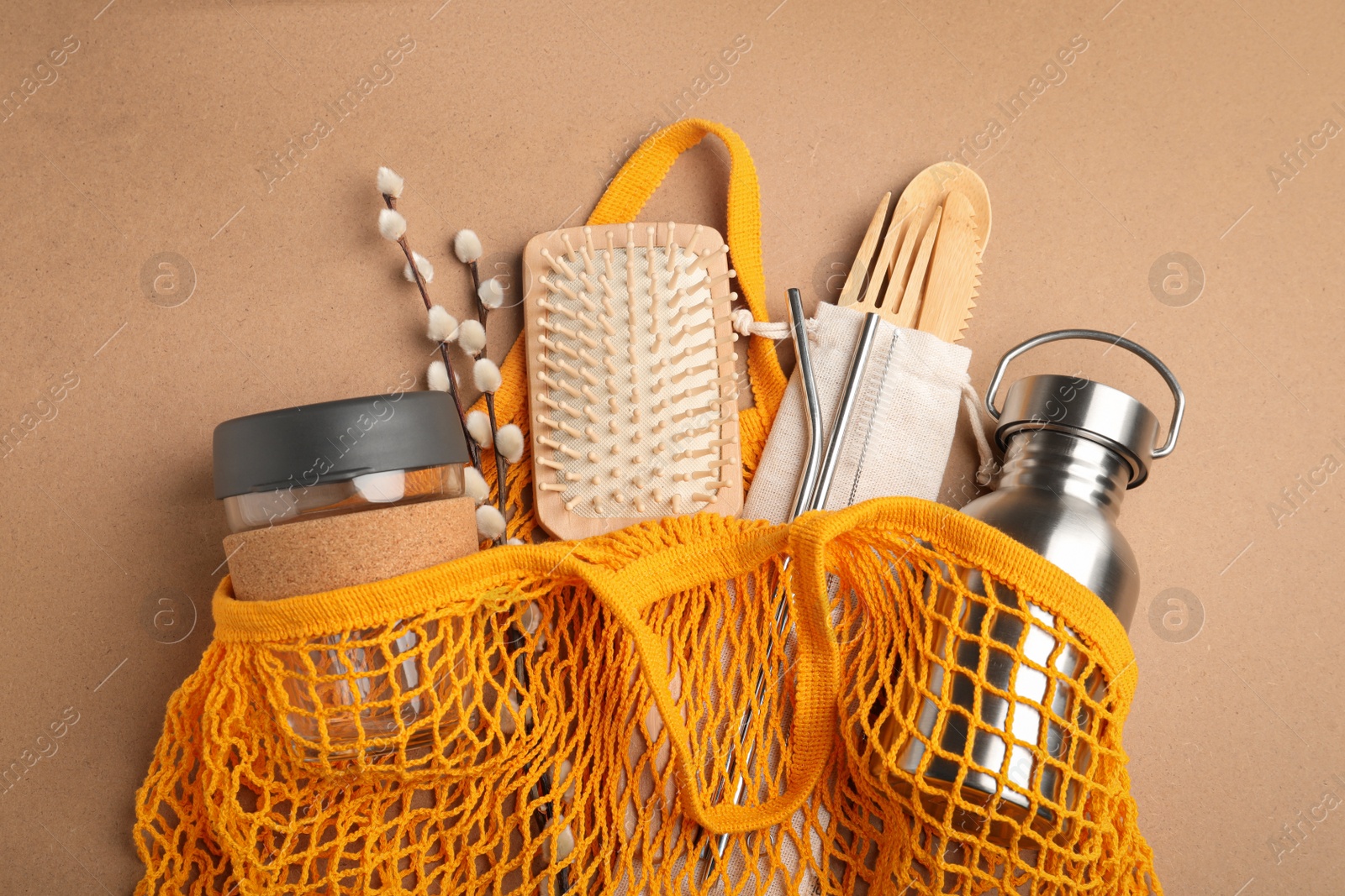 Photo of Bag with eco friendly products on brown background, top view